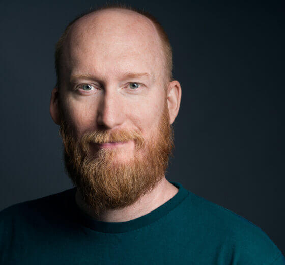Smiling photo of Flynn, a white male with a ginger colored beard