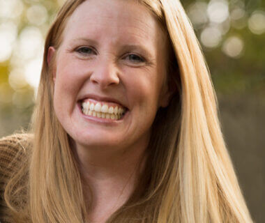 Close up photo of Courtney Matherly. She is wearing her long blonde hair down and a big smile.