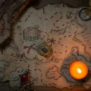 A ancient pirate treasure map lit by a single candle