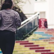 A woman running up multicolored stairs